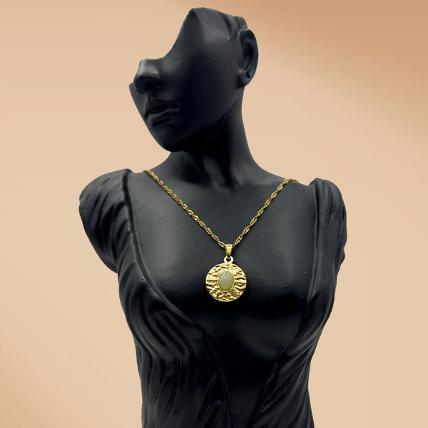 Mannequin wearing a gold necklace with a pendant on a beige background