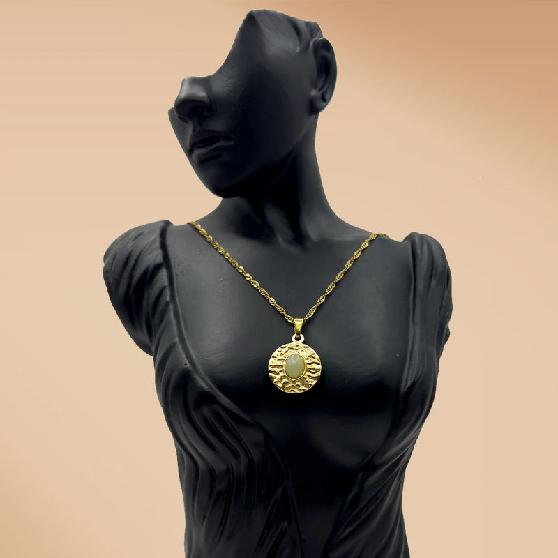 Mannequin wearing a gold necklace with a pendant on a beige background